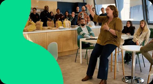 A photo of a company meeting being held in the office kitchen area