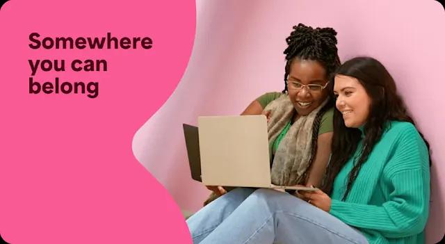 A photo of two employees working together on a laptop. There is a text overlay that says Somewhere you can belong