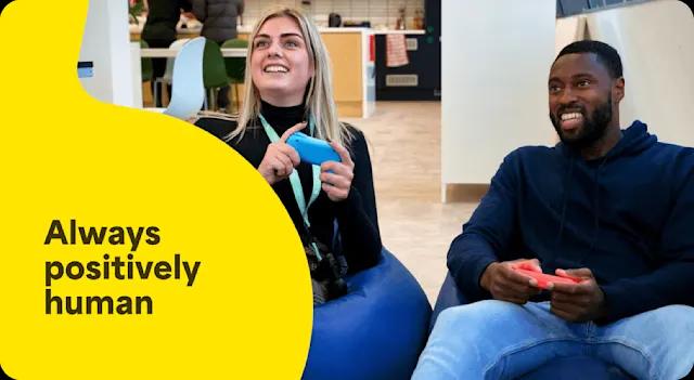 A photo of two employees who are having fun playing Nintendo Switch in the office entertainment area